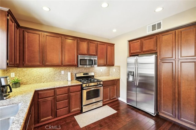 4437 Owens St Unit 104, Corona, CA 92883 - kitchen with appliances with stainless steel finishes, decorative backsplash, dark wood-style flooring, light stone countertops, and recessed lighting