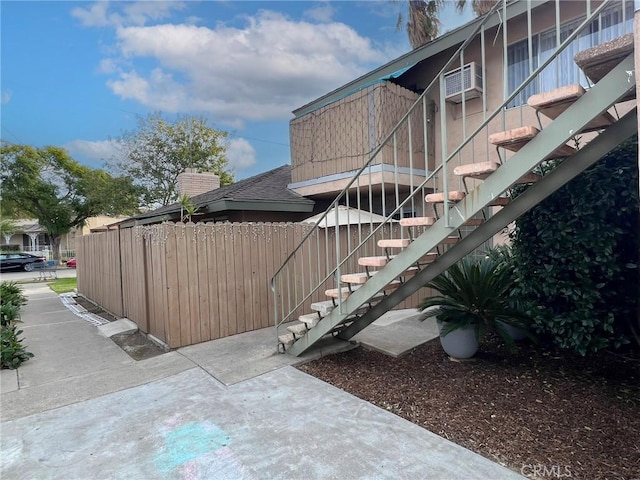 2562 N Bourbon St, Orange, CA 92865 - view of home's exterior with stairway, fence, and a wall unit AC