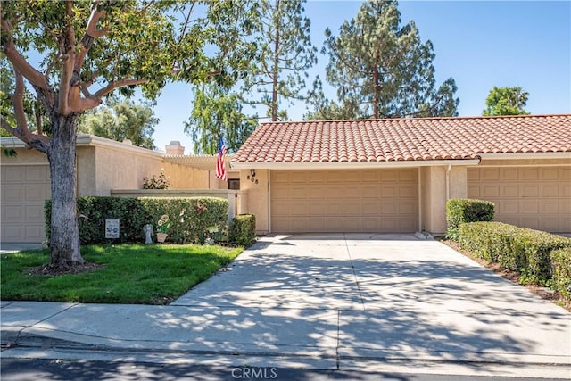 view of front of home with stucco siding, concrete driveway, a tile roof, and an attached garage