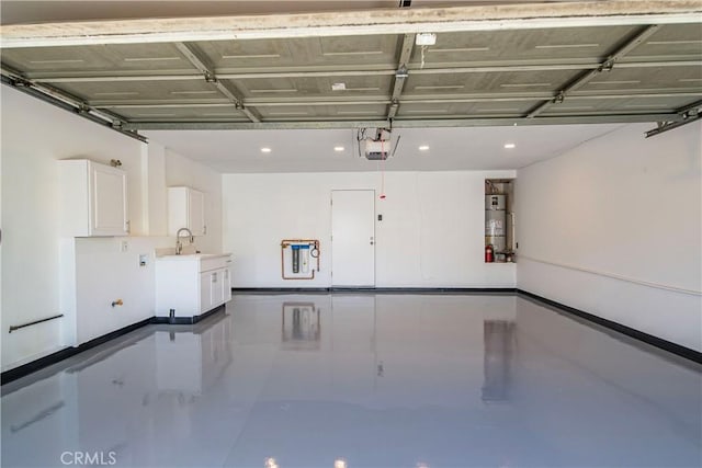 garage featuring strapped water heater, a garage door opener, a sink, and recessed lighting