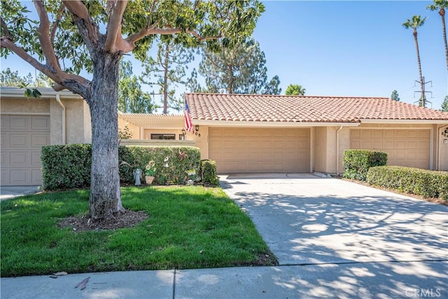 view of front facade featuring stucco siding, a tiled roof, a garage, and driveway
