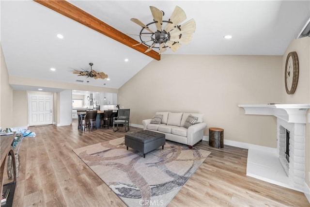 living area featuring ceiling fan, light wood-style floors, baseboards, recessed lighting, and a fireplace
