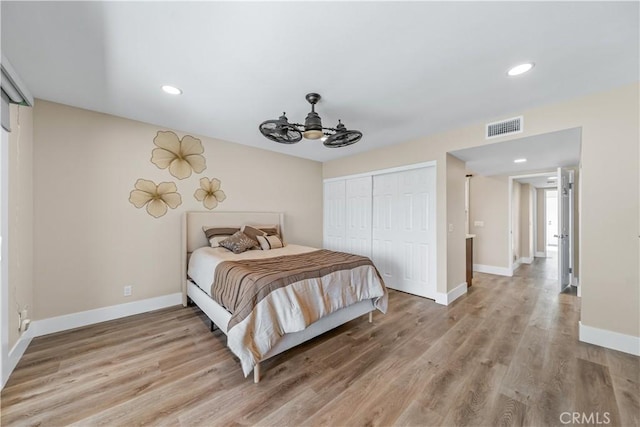 bedroom featuring recessed lighting, baseboards, light wood finished floors, and a closet