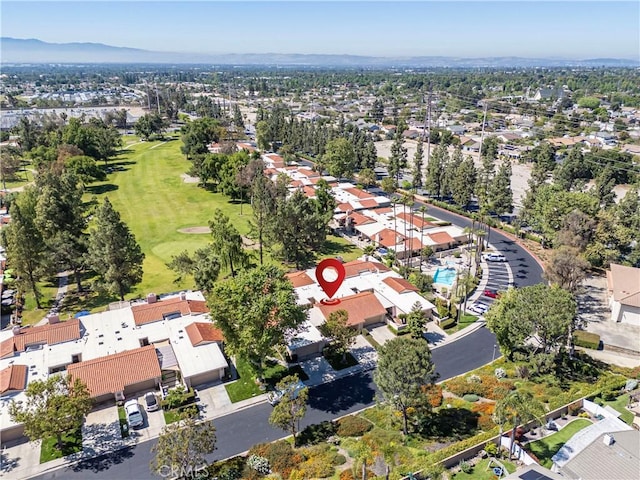 view of property location with nearby suburban area, a mountain backdrop, and a golf course