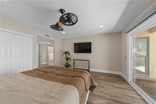 bedroom with wood finished floors, access to outside, baseboards, a closet, and recessed lighting