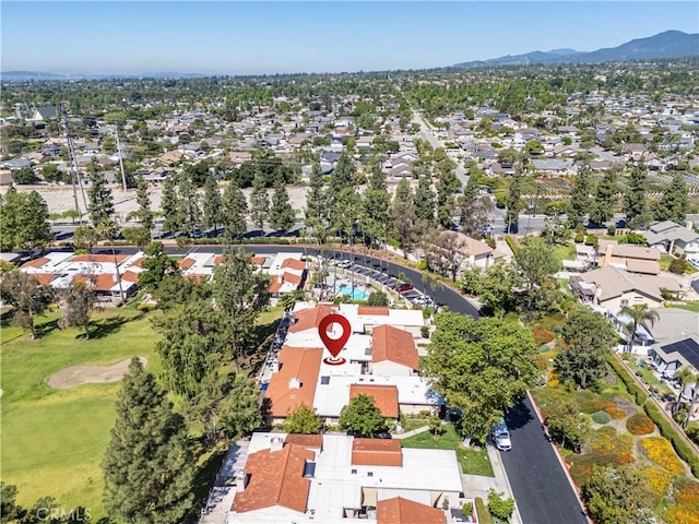 aerial perspective of suburban area featuring a mountain backdrop and a golf course