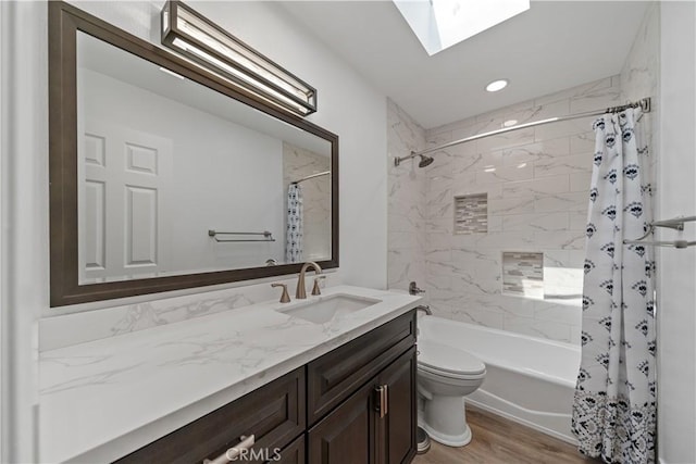 bathroom featuring vanity, toilet, shower / bath combo, wood finished floors, and a skylight