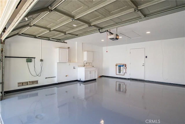 garage with a garage door opener and a sink