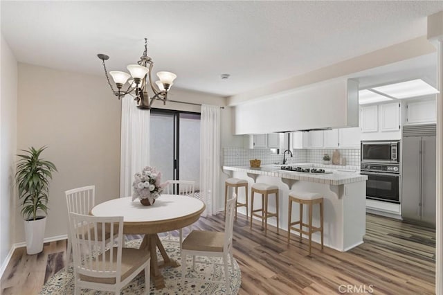676 Shepard St Unit 6, San Pedro, CA 90731 - dining space with a chandelier, light wood-style floors, and baseboards