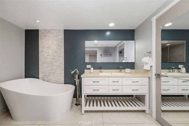 5653 Franklin Ave, Los Angeles, CA 90028 - bathroom with marble finish floors, a freestanding bath, two vanities, and recessed lighting