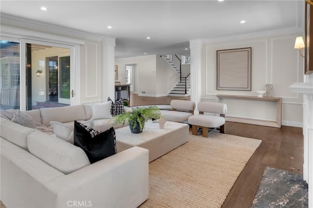 living area with stairway, wood finished floors, ornamental molding, recessed lighting, and a decorative wall