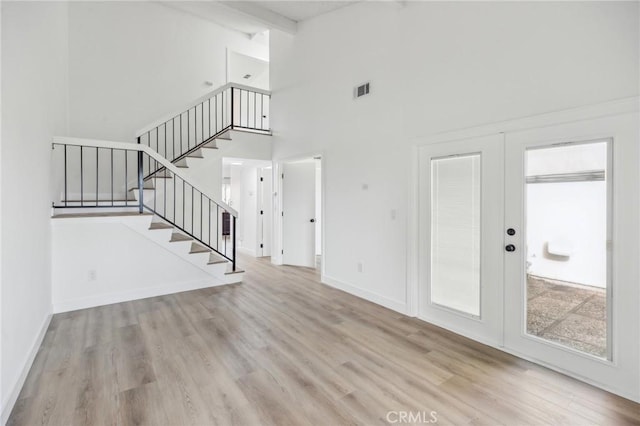 1326 Via Del Rio, Corona, CA 92882 - unfurnished living room with high vaulted ceiling, wood finished floors, french doors, stairs, and beam ceiling