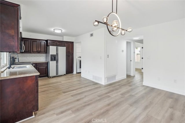 1326 Via Del Rio, Corona, CA 92882 - kitchen with white fridge with ice dispenser, stainless steel microwave, gas stove, and light wood-style flooring