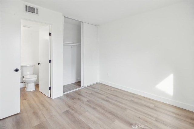 1326 Via Del Rio, Corona, CA 92882 - unfurnished bedroom featuring light wood finished floors, a closet, baseboards, and connected bathroom