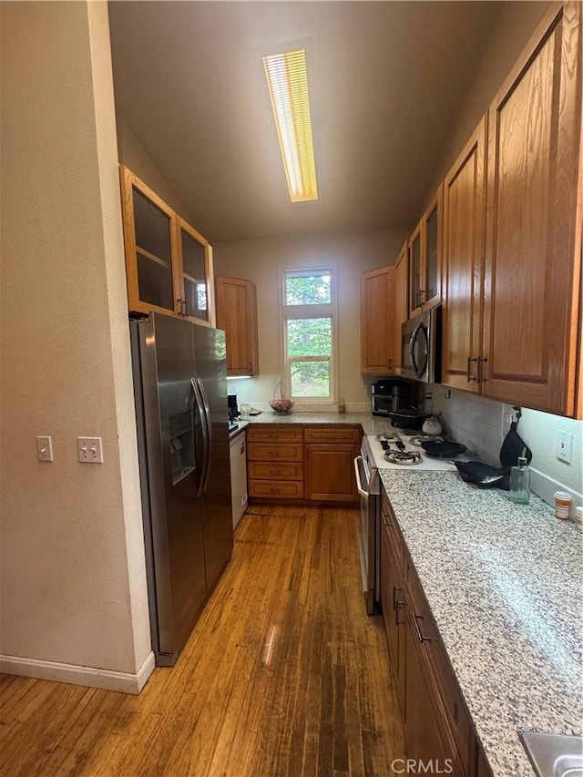 5625 Headwaters Rd, Forest Ranch, CA 95942 - kitchen featuring refrigerator with ice dispenser, stainless steel microwave, gas range oven, hardwood / wood-style floors, and glass insert cabinets