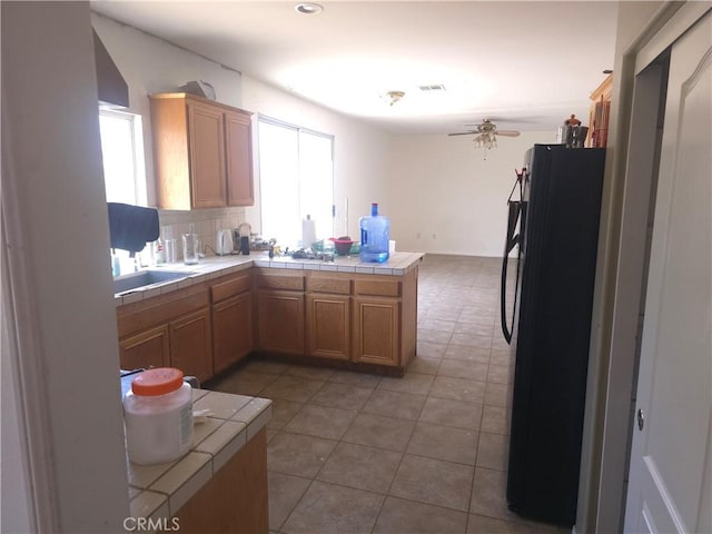 242 Spinnaker St, San Jacinto, CA 92583 - kitchen featuring freestanding refrigerator, tile countertops, plenty of natural light, and ceiling fan