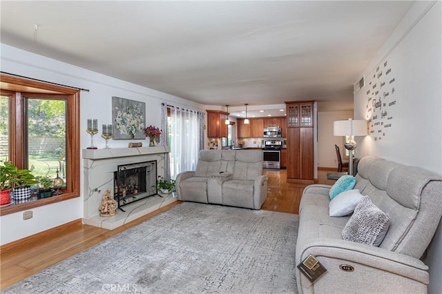 14048 Wagon Mound Rd, Rancho Cascades, CA 91342 - living room with healthy amount of natural light, light wood-style floors, a fireplace, and baseboards