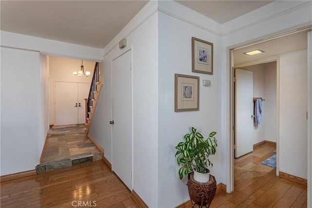 14048 Wagon Mound Rd, Rancho Cascades, CA 91342 - hall with light wood-type flooring, stairway, baseboards, and a chandelier