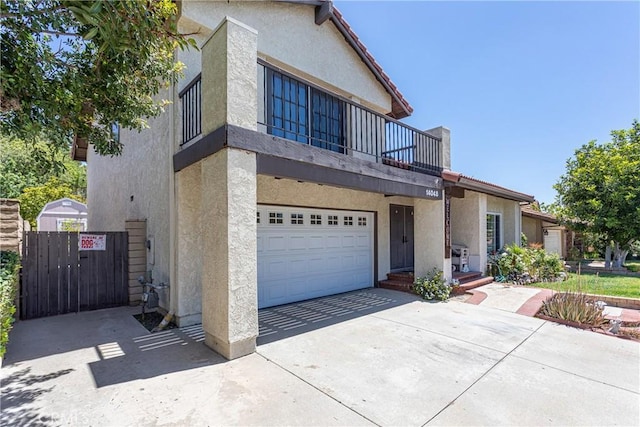 14048 Wagon Mound Rd, Rancho Cascades, CA 91342 - townhome / multi-family property featuring stucco siding, a balcony, a garage, and driveway