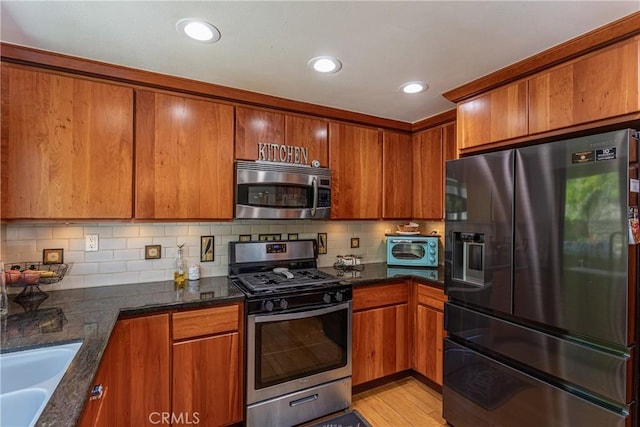 14048 Wagon Mound Rd, Rancho Cascades, CA 91342 - kitchen featuring stainless steel appliances, brown cabinetry, dark stone counters, and recessed lighting