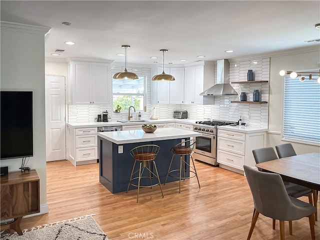 5253 Deeboyar, Lakewood, CA 90712 - kitchen with high end range, wall chimney range hood, a breakfast bar, a center island, and white cabinets