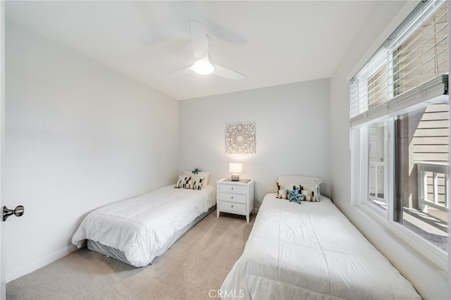 bedroom featuring light colored carpet and a ceiling fan