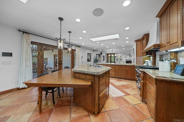 kitchen featuring premium range hood, plenty of natural light, double oven range, a sink, and recessed lighting