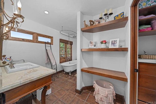 bathroom featuring a freestanding bath, vanity, and baseboards