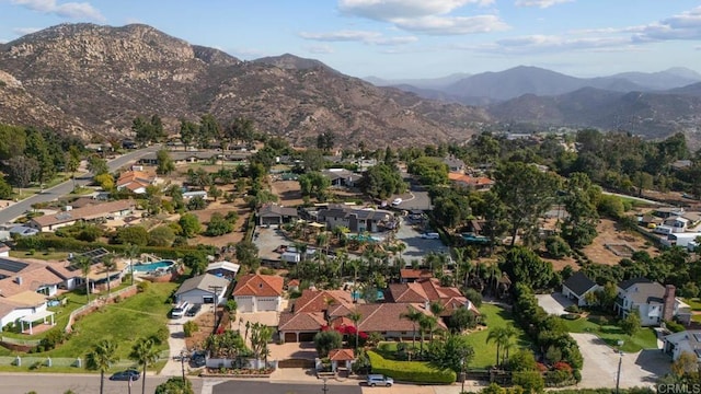 aerial overview of property's location with a mountainous background and nearby suburban area