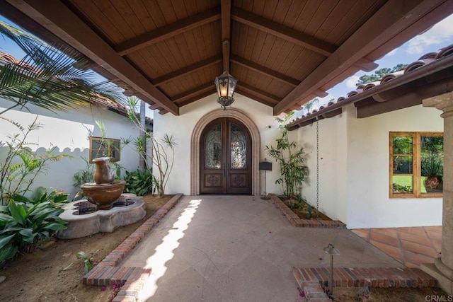 entrance to property featuring stucco siding and french doors