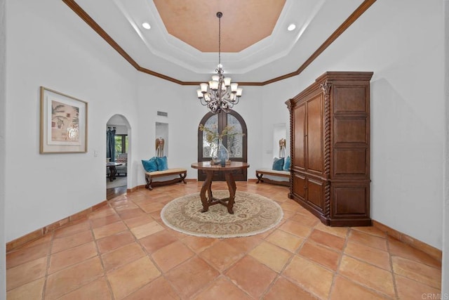 office area featuring arched walkways, a chandelier, baseboards, crown molding, and a towering ceiling