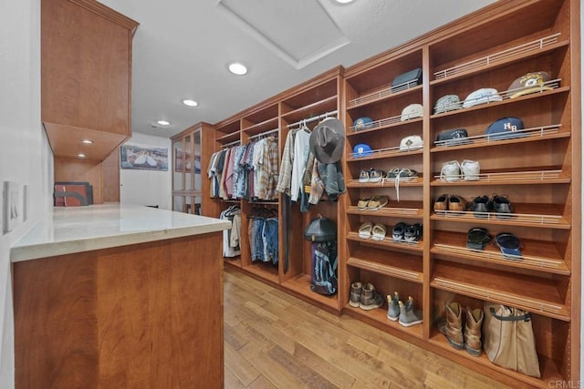 spacious closet featuring attic access and light wood finished floors