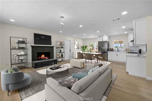 40635 159th St E, Lancaster, CA 93535 - living area with recessed lighting, light wood finished floors, and a brick fireplace