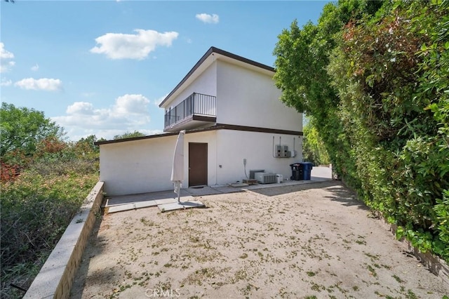12218 Sarazen Pl, Granada Hills, CA 91344 - rear view of house featuring a balcony, central AC unit, a patio, and stucco siding