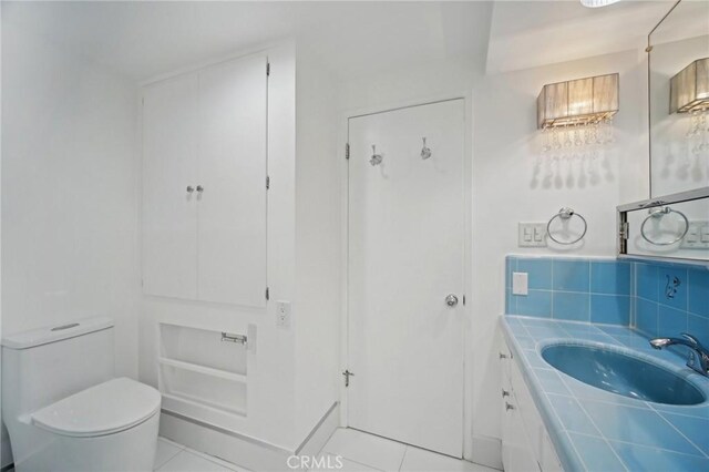 12218 Sarazen Pl, Granada Hills, CA 91344 - half bath with tile patterned flooring, toilet, backsplash, and vanity