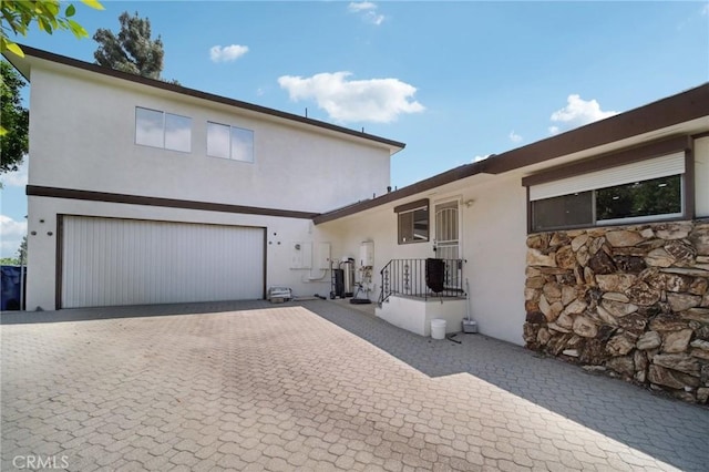 12218 Sarazen Pl, Granada Hills, CA 91344 - view of front of house with a garage, driveway, and stucco siding