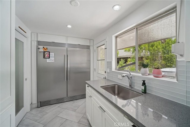 12218 Sarazen Pl, Granada Hills, CA 91344 - kitchen with built in fridge, a sink, stone countertops, white cabinets, and backsplash