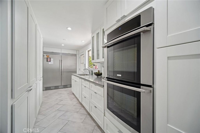 12218 Sarazen Pl, Granada Hills, CA 91344 - kitchen with stainless steel appliances, a sink, white cabinets, glass insert cabinets, and recessed lighting
