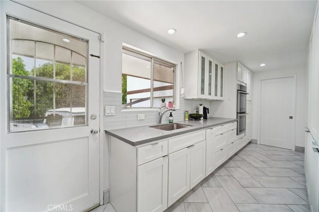12218 Sarazen Pl, Granada Hills, CA 91344 - kitchen with a sink, glass insert cabinets, white cabinetry, tasteful backsplash, and recessed lighting