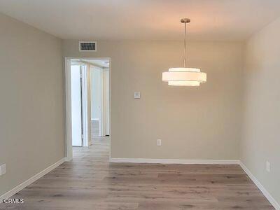 unfurnished dining area featuring wood finished floors and baseboards