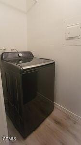 laundry area featuring washer / clothes dryer, wood finished floors, and baseboards