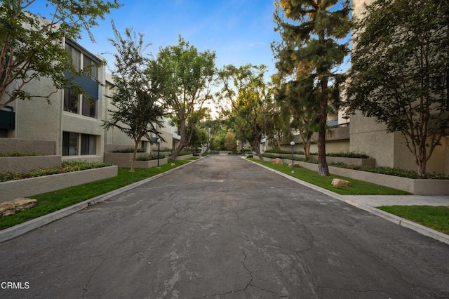 view of asphalt street featuring curbs, a residential view, and sidewalks