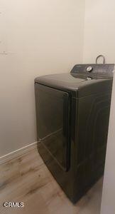 washroom with washer / clothes dryer, baseboards, and light wood finished floors