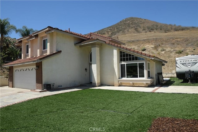 16971 Lakepointe Dr, Riverside, CA 92503 - view of front of home with a mountain view, stucco siding, an attached garage, driveway, and a tile roof