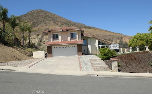 16971 Lakepointe Dr, Riverside, CA 92503 - view of front of house with a mountain view, driveway, stucco siding, and a garage