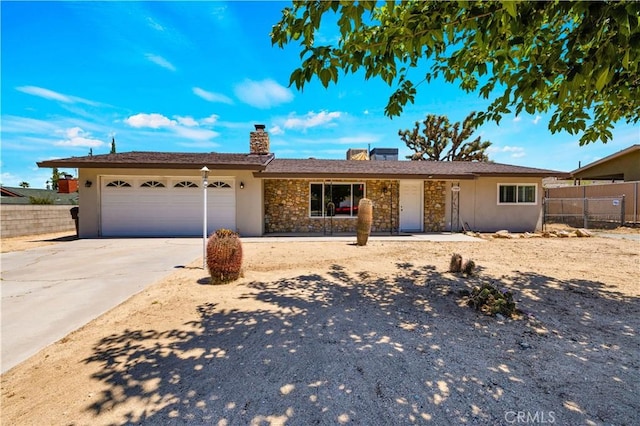 7599 Joshua Ln, Yucca Valley, CA 92284 - single story home with a chimney, stone siding, stucco siding, concrete driveway, and a garage