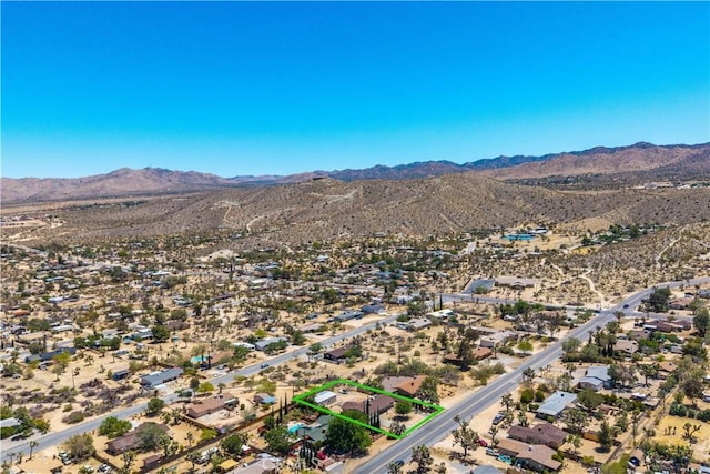 7599 Joshua Ln, Yucca Valley, CA 92284 - aerial overview of property's location with mountains, property parcel outlined, and a desert landscape