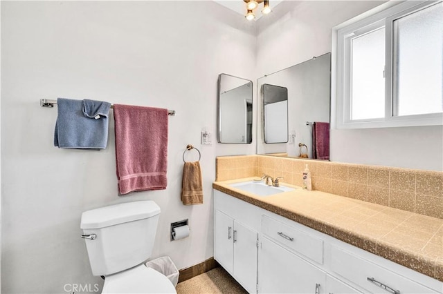 7599 Joshua Ln, Yucca Valley, CA 92284 - bathroom featuring toilet, vanity, backsplash, and baseboards