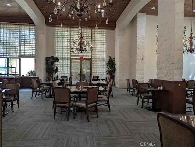 24055 Paseo Del Lago Unit 963, Laguna Woods, CA 92637 - carpeted dining space with a chandelier, arched walkways, a towering ceiling, and wooden ceiling with exposed beams