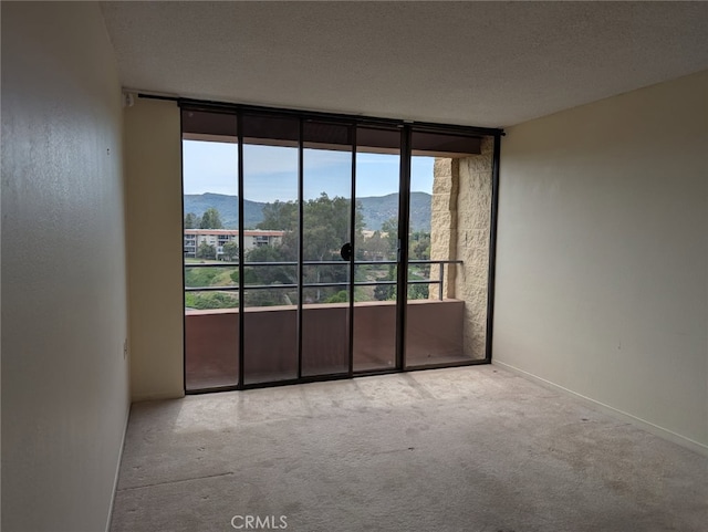 24055 Paseo Del Lago Unit 963, Laguna Woods, CA 92637 - carpeted spare room with a mountain view, expansive windows, and baseboards